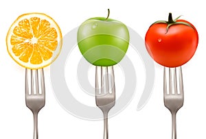 Lemon, tomato and apple on forks