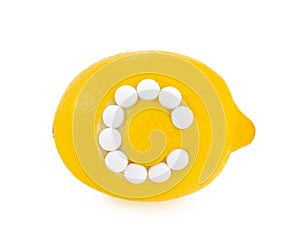 Lemon with vitamin c pills over white background