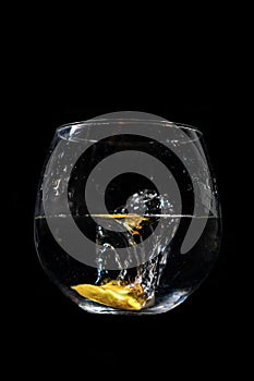 Lemon water splash in a glass with a black background