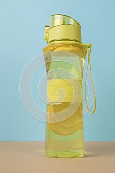 Lemon water in a yellow bottle on a blue background