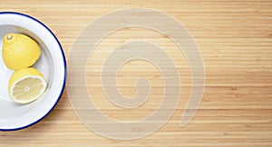 Lemon on white plate and wooden background