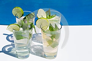 Lemonade against blue background, with mint and lime