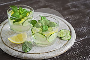 Lemonade with cucumber, lemon, mint and ginger in glass cups