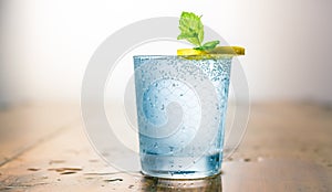Lemonade drink of soda water, lemon and mint leaves in a glass on white background