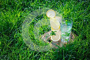 Lemonade in a glass on green grass