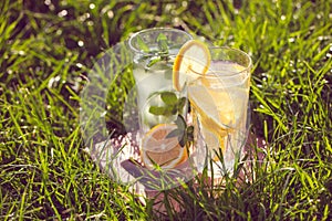 Lemonade in a glass on green grass