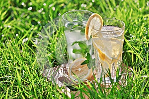 Lemonade in a glass on green grass