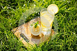 Lemonade in a glass on green grass
