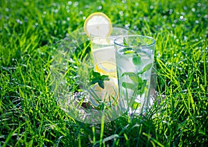 Lemonade in a glass on green grass