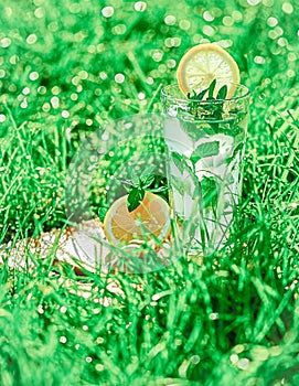 Lemonade in a glass on green grass