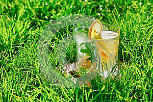 Lemonade in a glass on green grass