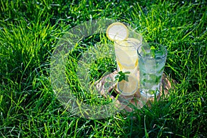 Lemonade in a glass on green grass