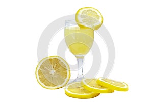 Lemonade in glass and sliced pieces lemons on white background.