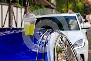 Lemonade in a road trip. a cup of lemonade is on the roof of a car