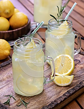 Lemonade with sliced lemons, ice and rosemary