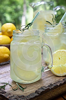 Lemonade with sliced lemons, ice and rosemary