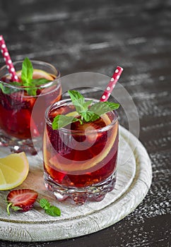 Lemonade with strawberries, lemon and mint in glass beakers