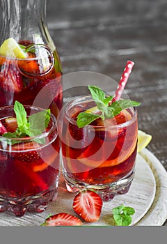 Lemonade with strawberries, lemon and mint in glass beakers