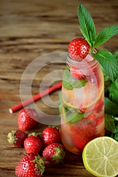 Lemonade with strawberry, lime, ice cubes and mint