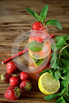 Lemonade with strawberry, lime, ice cubes and mint