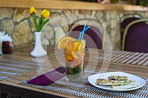 Lemonade or tropical cocktail with lemon, orange and mint, cold refreshing drink or beverage with ice in summer cafe