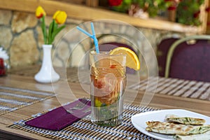 Lemonade or tropical cocktail with lemon, orange and mint, cold refreshing drink or beverage with ice in summer cafe