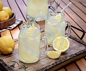 Lemonade with sliced lemons, ice and rosemary