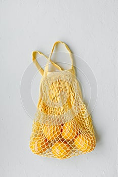 Lemons bananas and oranges in a string bag, shopping bag