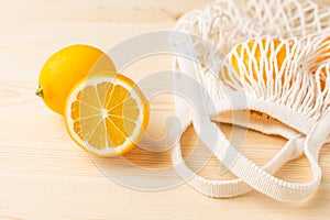 Lemons in cotton shopping eco friendly bag on wooden background. Help for colds, natural remedies for the disease