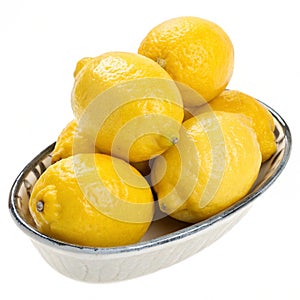 Lemons in a dish isolated on white background