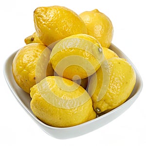 Lemons in a dish isolated on white background