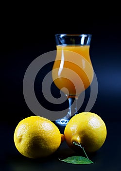 Lemons and juice glass on a black