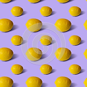 Lemons on lilic background, flat lay, top view, pattern.