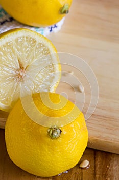 Lemons, pips and cloth on wooden board background with copyspace