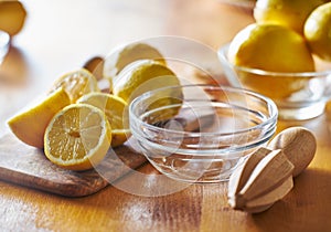 Lemons with wooden reamer ready to be juiced and squeezed