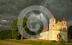 Lenas catholic church and dramatic, dark storm clouds in sunny summer evening, Latvia photo