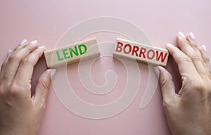 Lend or Borrow symbol. Concept word Lend or Borrow on wooden blocks. Businessman hand. Beautiful pink background. Business and