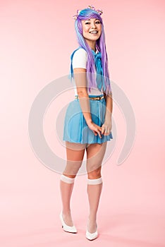 Length view of otaku girl in purple wig smiling on pink