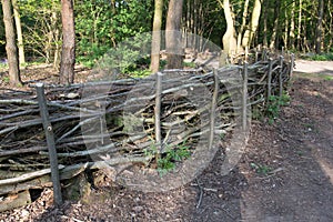 A barrier or fence made from lengths of brushwood and timber.