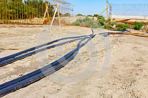 Lengthy black plastic water pipes on the construction site