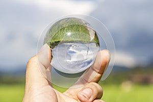 Lens ball with inverted paddy field and sky view inside