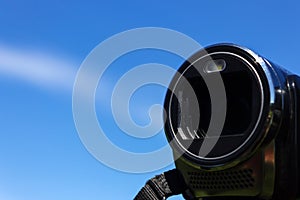 Lens camcorder on blue sky background