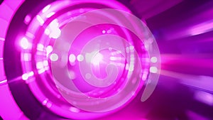 Through the lens of a camera bright purple and green laser beams are shown bouncing off a polished silicon wafer as it