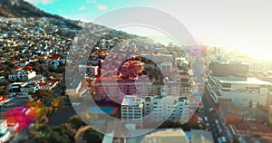 Lens flare, aerial drone view of urban city and suburban neighborhood in summer sun. Cape Town suburbs from above house