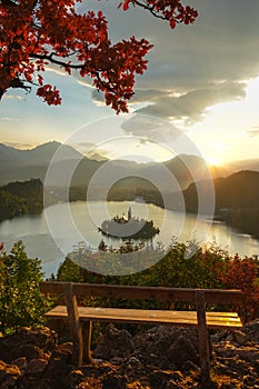 LENS FLARE: Golden sunrise shines on the idyllic lake Bled and the church.