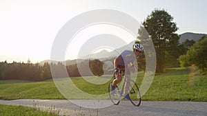 LENS FLARE: Pro rider struggles pedaling uphill during countryside bicycle race.
