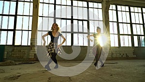 Lens flare on women dancers practicing in old factory hall in the evening