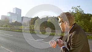 LENS FLARE: Young businessman checks watch and finds out he is late for work.