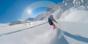 LENS FLARE: Young woman shreds the cold smoke snow while heli boarding in Canada