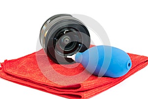 Lens, microfiber cloth and dust blower isolated on white background. Photography equipment cleaning